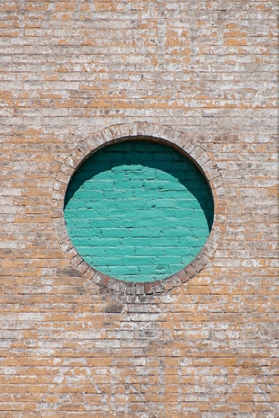 棕色砖墙配蓝色圆形玻璃窗